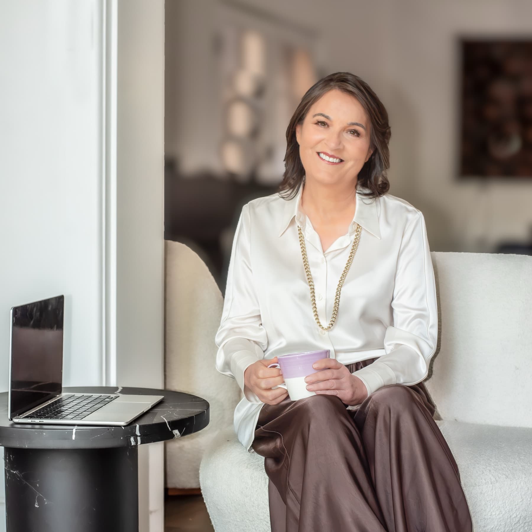 Paula Flynn seated in a sunlit living room